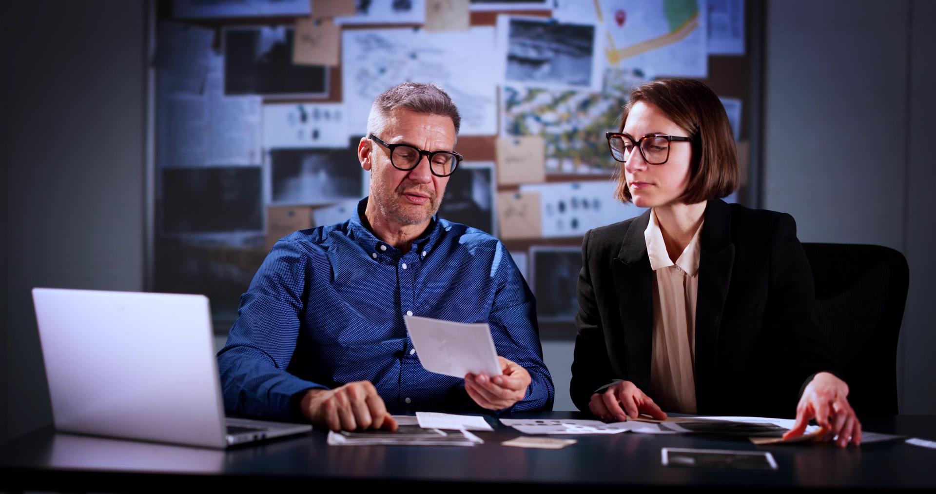 Private Detectives Doing Crime Investigation In Office